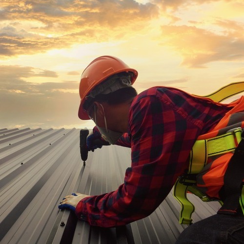 A Roofer Works on a Metal Roof