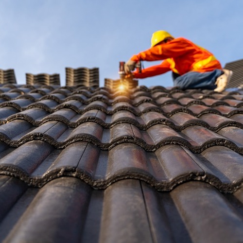 A Roofer Works on a Tile Roof