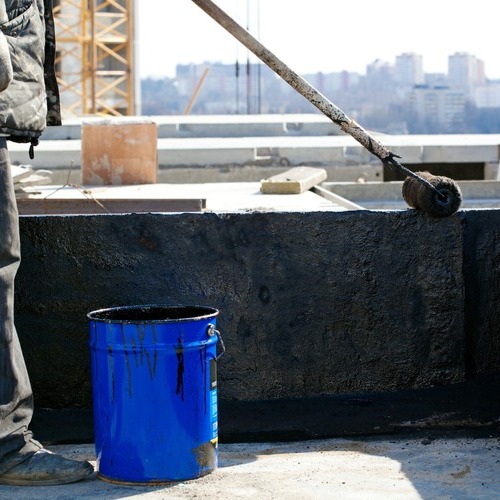 A Roofer Applies Roofing Tar.