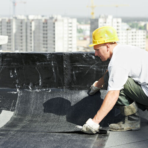 A Roofer Works on a Commercial Building