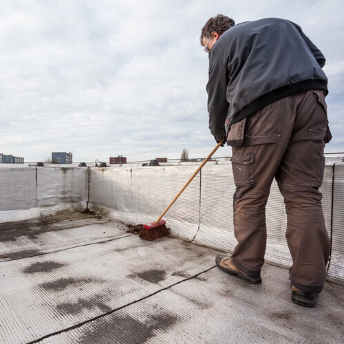 A Worker Cleans a Roof.