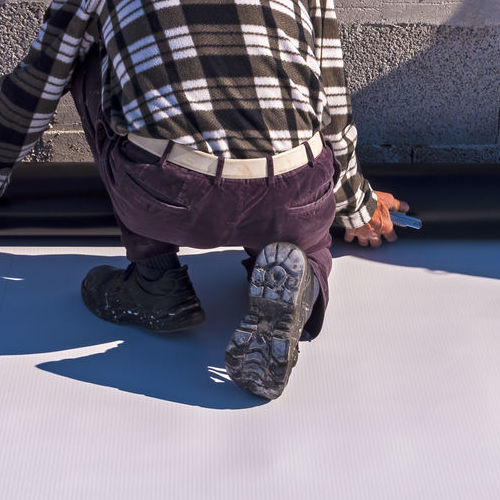 A Roofer Installs TPO.