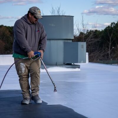 A Contractor Applies a Roof Coating